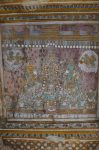 Title: Kallagar Temple complex; Vasanta mandapa; Alagar Koyil Date: 18th centuryDescription: Alagar with Sridevi on his right, Kalyana Sundaravalli Nacchiyar, on his left and other deities (as seen in the main sanctuary); In the upper corners gandharvis throw flower petals on them; In the foreground ritual implements.  Location: Tamil NaduTemple;Kallagar Temple complex;Alagar Koyil Positioning: Vasanta mandapa; ceiling of the central pavilion