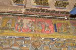 Title: Atmanatha Temple; Avudaiyarkoyil (Tirupperunturai) Date: Paintings: late 19th, early 20th centuryDescription: Top row: Arimarttana Pandya (Varagunavarman II) waits a couple of days; then he orders Manikkavachakar to return all the funds he had taken from the treasury; He orders to place a heavy block of granite on his head, he is made to carry a huge stone on his back and finally he is imprisoned.  Location: Tamil Nadu Temple;Atmanatha Temple;Avudaiyarkoyil Positioning: Sivananda Manikkavachakar shrine, west face