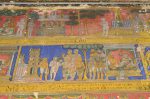 Title: Atmanatha Temple; Avudaiyarkoyil (Tirupperunturai) Date: Paintings: late 19th, early 20th centuryDescription: Top row: Unidentified episodes involving Manikkavachakar and a swarm of dragonflies; A group of ladies around a trough; Second row:  Manikkavachakar and his companions before the Chola king, debate with the Buddhists. Location: Tamil Nadu Temple;Atmanatha Temple;Avudaiyarkoyil Positioning: Sivananda Manikkavachakar shrine, north face